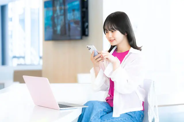 スマートフォンを見る学生