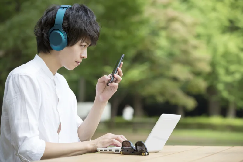 外でスマホを見る男性